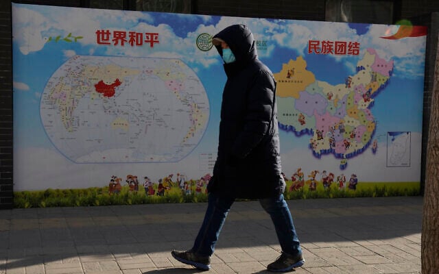 A man walks past a poster with the slogans 'World Peace' and 'Ethnic Unity' in Beijing, China, Jan. 11, 2021 (AP Photo/Ng Han Guan) A man walks past a poster with the slogans 'World Peace' and 'Ethnic Unity' in Beijing, China, Jan. 11, 2021 (AP Photo/Ng Han Guan)
