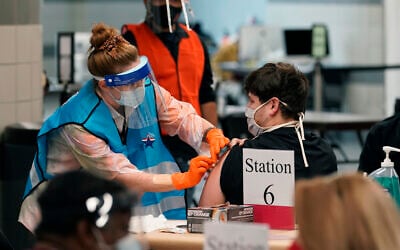A health care worker administers a COVID-19 vaccination at the new Alamodome COVID-19 vaccine site, Jan. 11, 2021, in San Antonio, Texas (AP Photo/Eric Gay)