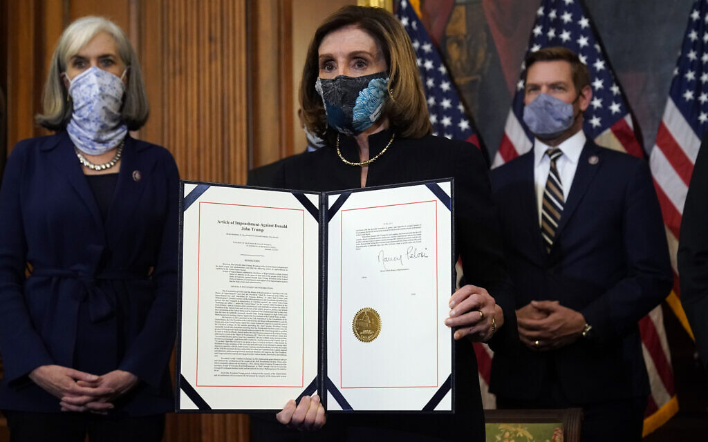 House Speaker Nancy Pelosi of Calif., displays the signed article of impeachment against US President Donald Trump in an engrossment ceremony before transmission to the Senate for trial on Capitol Hill, in Washington, Wednesday, January 13, 2021. (AP Photo/Alex Brandon) House Speaker Nancy Pelosi of Calif., displays the signed article of impeachment against US President Donald Trump in an engrossment ceremony before transmission to the Senate for trial on Capitol Hill, in Washington, Wednesday, January 13, 2021. (AP Photo/Alex Brandon)
