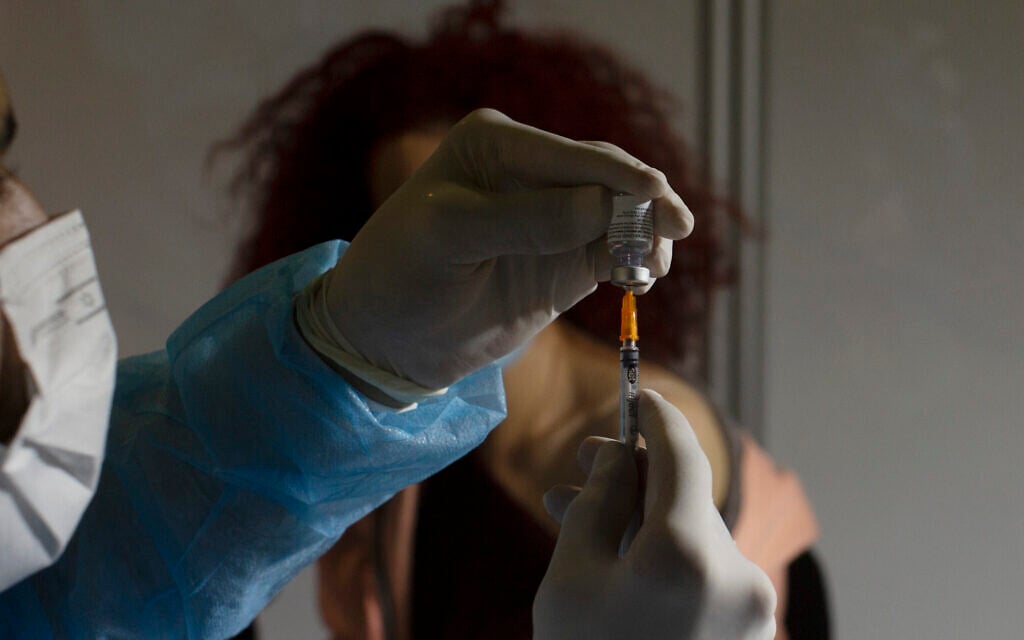 A medical professional prepares to administer the Pfizer COVID-19 vaccine to a woman at a makeshift vaccination center in a sports arena in Jerusalem, Jan. 14, 2021. (AP Photo/Maya Alleruzzo) A medical professional prepares to administer the Pfizer COVID-19 vaccine to a woman at a makeshift vaccination center in a sports arena in Jerusalem, Jan. 14, 2021. (AP Photo/Maya Alleruzzo)