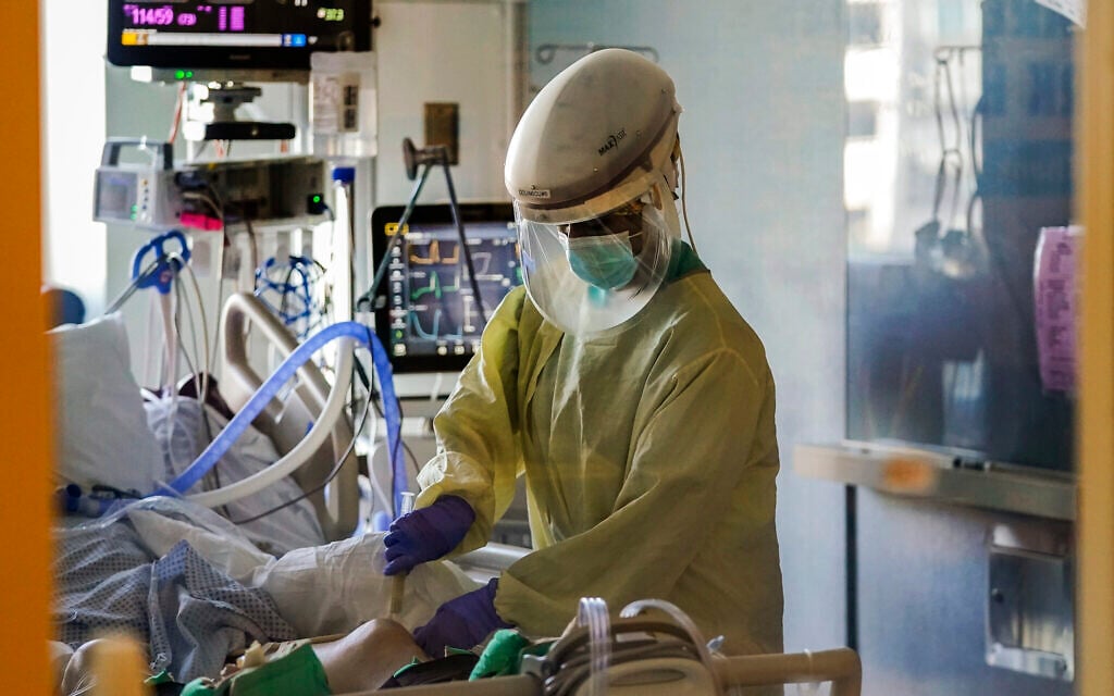 A healthcare worker tends to a COVID-19 patient in the intensive care unit at Santa Clara Valley Medical Center during the coronavirus pandemic in San Jose, California, January 13, 2021. (AP Photo/Jeff Chiu, File)