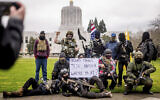 Armed protesters, who identified themselves as Liberty Boys, pose for fellow demonstrators' pictures outside the Oregon State Capitol on Jan. 17, 2021, in Salem, Oregon (AP Photo/Noah Berger)