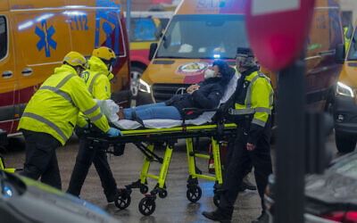 Health professionals evacuate an injured from the scene of an explosion in downtown Madrid, Spain on Jan. 20, 2021. (AP Photo/Paul White)