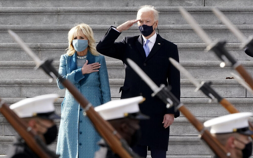 US President Joe Biden and his wife Jill Biden watch a military pass in review ceremony on the East Front of the Capitol at the conclusion of the inauguration ceremonies, in Washington, January 20, 2021. (AP/J. Scott Applewhite) US President Joe Biden and his wife Jill Biden watch a military pass in review ceremony on the East Front of the Capitol at the conclusion of the inauguration ceremonies, in Washington, January 20, 2021. (AP/J. Scott Applewhite)