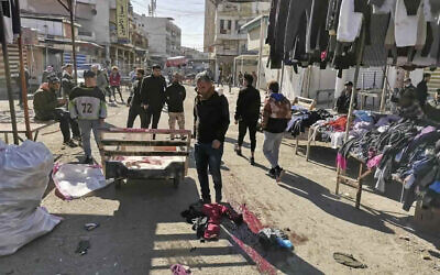 Civilians and security forces gather at the site of a deadly bomb attack in Baghdad's bustling commercial area, Iraq, January 21, 2021. (AP Photo/Hadi Mizban)