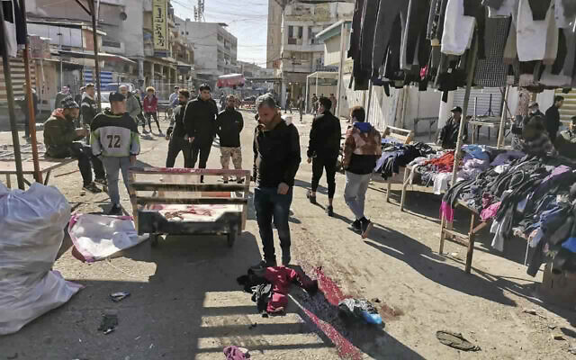 Civilians and security forces gather at the site of a deadly bomb attack in Baghdad's bustling commercial area, Iraq, January 21, 2021. (AP Photo/Hadi Mizban) Civilians and security forces gather at the site of a deadly bomb attack in Baghdad's bustling commercial area, Iraq, January 21, 2021. (AP Photo/Hadi Mizban)