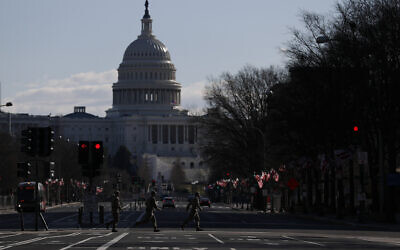 National Guard members jog across a road leading to the Capitol, after most downtown streets and public spaces had reopened to the public following the inauguration of President Joe Biden, on Saturday, Jan. 23, 2021 in Washington.(AP Photo/Rebecca Blackwell)