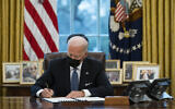 US President Joe Biden signs an executive order in the Oval Office of the White House, in Washington, January 25, 2021. (Evan Vucci/AP)