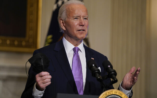 President Joe Biden holds his face mask as he delivers remarks on COVID-19, in the State Dining Room of the White House, Tuesday, Jan. 26, 2021, in Washington. (AP/Evan Vucci) President Joe Biden holds his face mask as he delivers remarks on COVID-19, in the State Dining Room of the White House, Tuesday, Jan. 26, 2021, in Washington. (AP/Evan Vucci)