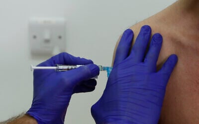 Novavax coronavirus vaccine trial volunteer Franklyn Howe is given an injection at St George's University hospital in London, Oct. 7, 2020. (AP Photo/Alastair Grant)