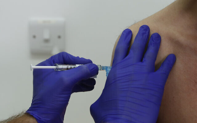 Novavax coronavirus vaccine trial volunteer Franklyn Howe is given an injection at St George's University hospital in London, Oct. 7, 2020. (AP Photo/Alastair Grant)