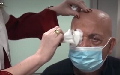 Prof. Irit Bahar, director of the Ophthalmology Department at Rabin Medical Center, removes the bandages from Jamal Furani, after he got the artificial cornea implant developed by CorNeat Vision (Channel 13 screenshot)