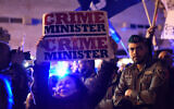 An Israeli woman carries a sign as Left-wing and Right-wing demonstrators are separated by police during protests in support and against Prime Minister Benjamin Netanyahu in Tel Aviv on March 02, 2019. (Gili Yaari/Flash90)