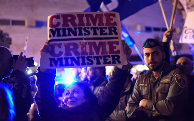 An Israeli woman carries a sign as Left-wing and Right-wing demonstrators are separated by police during protests in support and against Prime Minister Benjamin Netanyahu in Tel Aviv on March 02, 2019. (Gili Yaari/Flash90) An Israeli woman carries a sign as Left-wing and Right-wing demonstrators are separated by police during protests in support and against Prime Minister Benjamin Netanyahu in Tel Aviv on March 02, 2019. (Gili Yaari/Flash90)