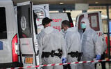 Prison guards wearing protective clothing as a preventive measure against the coronavirus, seen as they transport a prisoner suspected of having the coronavirus at Shaare Zedek Medical Center in Jerusalem on March 30, 2020. (Yossi Zamir/Flash90)