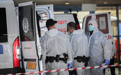 Prison guards wearing protective clothing as a preventive measure against the coronavirus, seen as they transport a prisoner suspected of having the coronavirus at Shaare Zedek Medical Center in Jerusalem on March 30, 2020. (Yossi Zamir/Flash90)