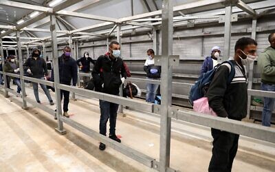Palestinian workers enter Israel through the Mitar checkpoint in the West Bank city of Hebron, on May 3, 2020. (Wisam Hashlamoun/Flash90)
