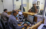 Palestinians receive their financial aid as part of assistance given by Qatar, at a post office in Rafah, in the southern Gaza Strip, on October 6, 2020. (Abed Rahim Khatib/Flash90)