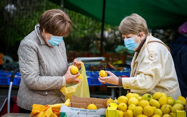Israeli women inspect lemons at the market in the northern city of Safed on December 9, 2020. (David Cohen/ Flash90) Israeli women inspect lemons at the market in the northern city of Safed on December 9, 2020. (David Cohen/ Flash90)