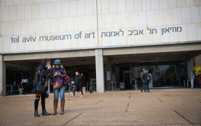 People wear protective face masks due to the coronavirus outbreak as they walk outside the Tel Aviv Museum of Art, December 17, 2020. (Miriam Alster/FLASH90)