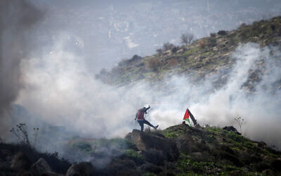 Illustrative: Israeli forces fire tear gas at Palestinians during a clash near  the West Bank city of Nablus on, December 18, 2020. (Nasser Ishtayeh/Flash90)