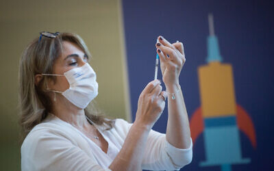 A medical worker prepares a COVID-19 vaccine in Ichilov Hospital in Tel Aviv on December 20, 2020. (Miriam Alster/Flash90)