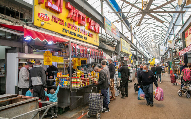 People shop at the at a market in Ramle, on January 1, 2021, during the third national lockdown due to the COVID-19 pandemic (Yossi Aloni/FLASH90) People shop at the at a market in Ramle, on January 1, 2021, during the third national lockdown due to the COVID-19 pandemic (Yossi Aloni/FLASH90)