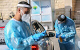 Medical workers test people at a drive-through site to collect samples for coronavirus testing in the northern city of Safed on January 4, 2021 (David Cohen/Flash90)
