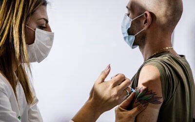 An Israeli man receives a COVID-19 vaccine in Jerusalem, on January 4, 2021. (Olivier Fitoussi/Flash90)