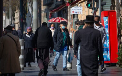 Jerusalemites wear face masks while walking on Jaffa Street on January 6, 2021, during the 3rd lockdown due to the COVID-19 coronavirus pandemic. (Olivier Fitoussi/Flash90)