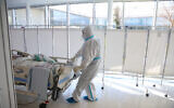 Hospital staff transport a new patient to the coronavirus ward of the Ziv medical center in the northern Israeli city of Safed, January 7, 2020. (David Cohen/Flash90)