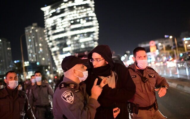 Police clash with protesters during a protest over the death Ahuvia Sandak in a car crash during a police chase, outside the home of Ministre of Public Security Amir Ohana in Tel Aviv, January 7, 2021. (Tomer Neuberg/Flash90) Police clash with protesters during a protest over the death Ahuvia Sandak in a car crash during a police chase, outside the home of Ministre of Public Security Amir Ohana in Tel Aviv, January 7, 2021. (Tomer Neuberg/Flash90)