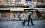 A man at the Mahane Yehuda market in Jerusalem on January 10, 2021, during a third nationawide coronavirus lockdown. (Yonatan Sindel/Flash90)