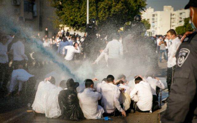 Young Haredi residents of Ashdod clash with police who were dispatched to shutter a yeshiva in the town that was operating in violation of the government lockdown on January 11, 2020. (Flash90) Young Haredi residents of Ashdod clash with police who were dispatched to shutter a yeshiva in the town that was operating in violation of the government lockdown on January 11, 2020. (Flash90)