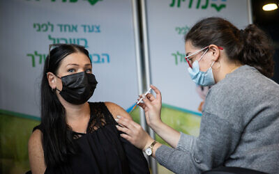 An education worker receives a COVID-19 vaccine injection, at a Clalit clinic in Jerusalem, January 12, 2021. (Yonatan Sindel/Flash90)