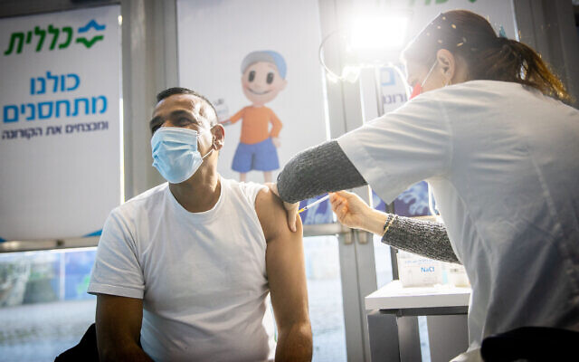 A man receives a coronavirus vaccine injection at Clalit vaccination center in Jerusalem on January 12, 2021. (Yonatan Sindel/Flash90)