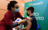 An Israeli student receives a COVID-19 vaccine injection, at a vaccination center in Tel Aviv, on January 23, 2021.  Currently, vaccines are mostly limited to over-16s, but this is expected to change soon. (Avshalom Sassoni/Flash90)
