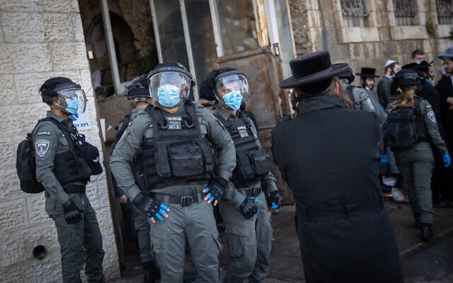 Israeli police officers clash with ultra-Orthodox men during enforcement of coronavirus emergency regulations, in Jerusalem, January 26, 2021 (Yonatan Sindel/Flash90) Israeli police officers clash with ultra-Orthodox men during enforcement of coronavirus emergency regulations, in Jerusalem, January 26, 2021 (Yonatan Sindel/Flash90)