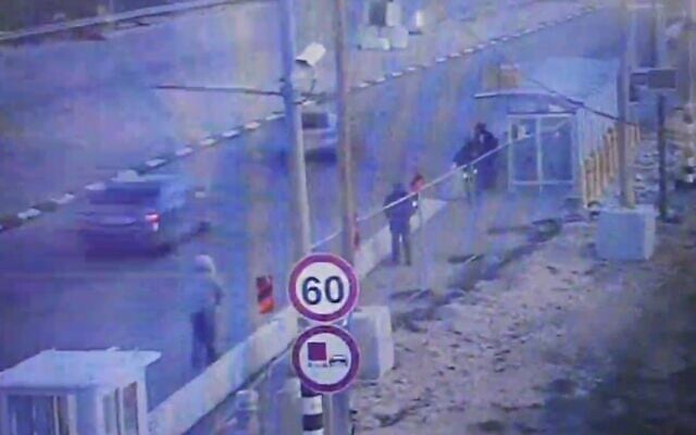 A Palestinian man wearing a grey jacket with a white hood, left, armed with a knife approaches an Israeli soldier guarding a bus stop at the Gush Etzion Junction in the southern West Bank before being shot on January 31, 2021. (Screen capture) A Palestinian man wearing a grey jacket with a white hood, left, armed with a knife approaches an Israeli soldier guarding a bus stop at the Gush Etzion Junction in the southern West Bank before being shot on January 31, 2021. (Screen capture)