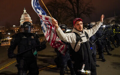 A police line moves a protestor outside of the US Capitol following violent riots there, January 6, 2021. (AP Photo/John Minchillo)