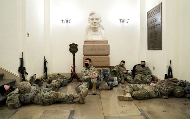 Members of the US National Guard rest in the US Capitol in Washington, January 13, 2021. (Stefani Reynolds/Getty Images/AFP)
