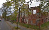 A woman walks past the ruins of the Great Lubavitch Synagogue in Vitebsk, Belarus. (Courtesy/Municipality of Vitebsk via JTA)