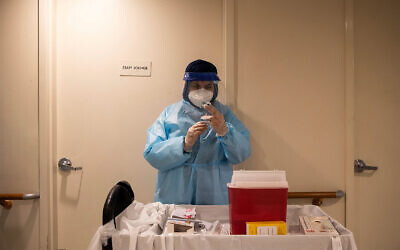 A pharmacist prepares a COVID-19 vaccine for nursing home residents in the Harlem neighborhood of New York, Jan. 15, 2021. (AP Photo/Yuki Iwamura)