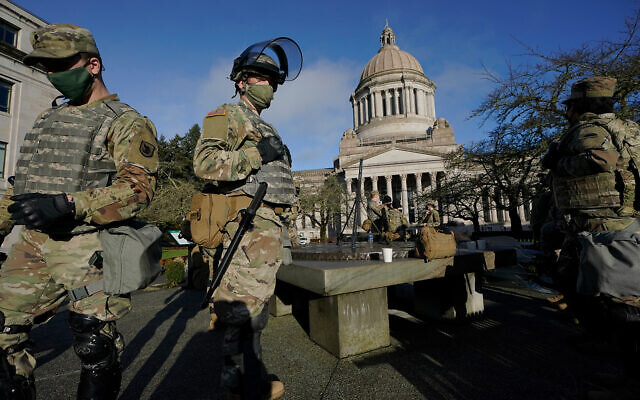 Members of the Washington National Guard stand near the Legislative Building at the state Capitol in Olympia, Washington, January 10, 2021. (AP Photo/Ted S. Warren) Members of the Washington National Guard stand near the Legislative Building at the state Capitol in Olympia, Washington, January 10, 2021. (AP Photo/Ted S. Warren)