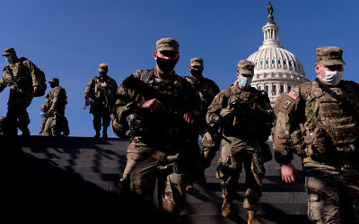 Members of the US National Guard walk past the Dome of the Capitol Building on Capitol Hill in Washington, January 14, 2021. (AP Photo/Andrew Harnik)