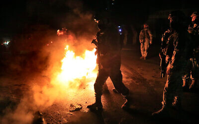Lebanese soldiers pass burned tires as they clash with protesters, during a protest against deteriorating living conditions and strict coronavirus lockdown measures, in Tripoli, Lebanon, January 29, 2021. (AP Photo/Hussein Malla)