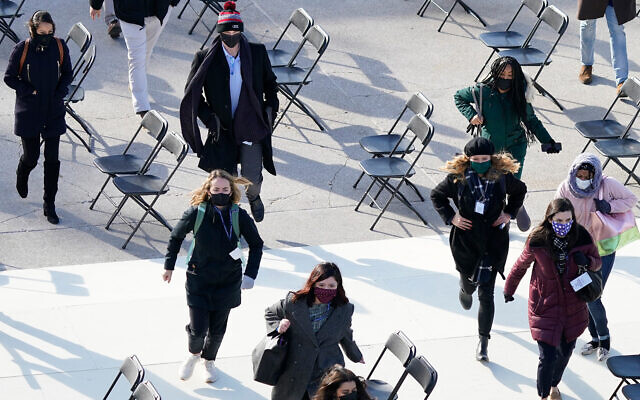 People evacuate from the West Front of the US Capitol, due to a false alarm during a rehearsal for the 59th presidential inauguration, in Washington, January 18, 2021. (AP Photo/Carolyn Kaster) People evacuate from the West Front of the US Capitol, due to a false alarm during a rehearsal for the 59th presidential inauguration, in Washington, January 18, 2021. (AP Photo/Carolyn Kaster)