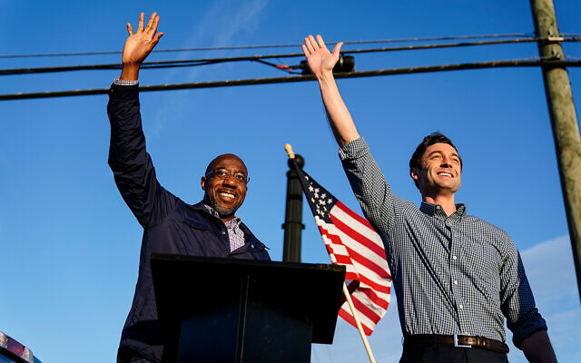 Then-Georgia Democratic candidates for US Senate Raphael Warnock, left, and Jon Ossoff, right, gesture toward a crowd during a campaign rally in Marietta, Georgia, November 15, 2020. (AP Photo/Brynn Anderson, File) Then-Georgia Democratic candidates for US Senate Raphael Warnock, left, and Jon Ossoff, right, gesture toward a crowd during a campaign rally in Marietta, Georgia, November 15, 2020. (AP Photo/Brynn Anderson, File)