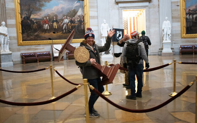 A pro-Trump rioter identified as Adam Johnson carries the lectern of US Speaker of the House Nancy Pelosi through the Roturnda of the US Capitol Building after a pro-Trump mob stormed the building on January 6, 2021. (Win McNamee/Getty Images/AFP) A pro-Trump rioter identified as Adam Johnson carries the lectern of US Speaker of the House Nancy Pelosi through the Roturnda of the US Capitol Building after a pro-Trump mob stormed the building on January 6, 2021. (Win McNamee/Getty Images/AFP)