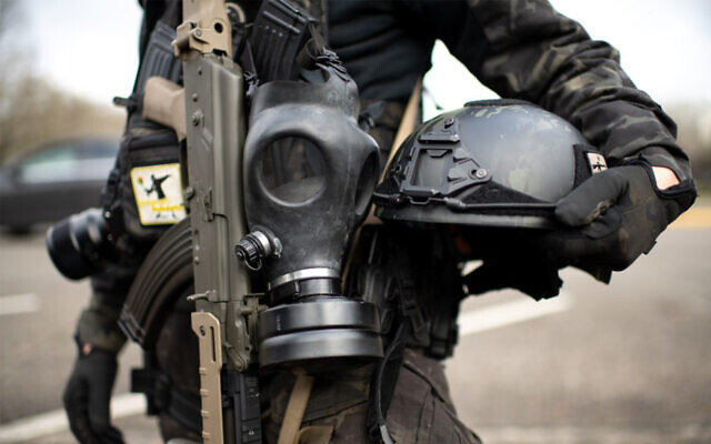 Illustrative: A member of the Boogaloo Boys extremist group stands armed with an assault rifle, gas mask and combat helmet outside of the Oregon State Capitol building in Salem, January 17, 2021. (Mathieu Lewis-Rolland/AFP) Illustrative: A member of the Boogaloo Boys extremist group stands armed with an assault rifle, gas mask and combat helmet outside of the Oregon State Capitol building in Salem, January 17, 2021. (Mathieu Lewis-Rolland/AFP)